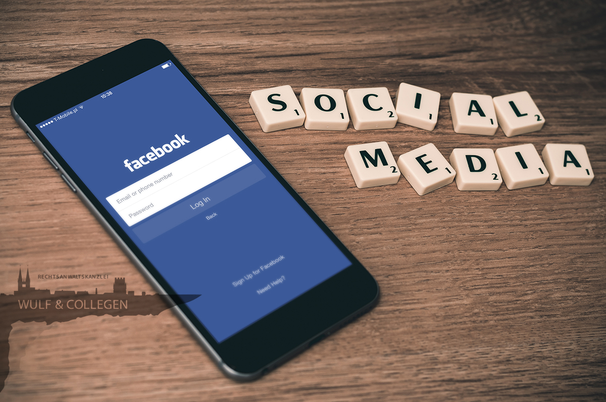 Ein Handy mit dem Facebook-Login, wo daneben Scrabble-Steine liegen, auf denen "Social Media" zu lesen ist